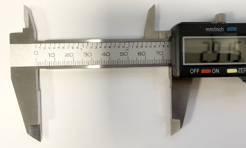 Close-up of digital caliper beam with fixed and sliding jaws on either side