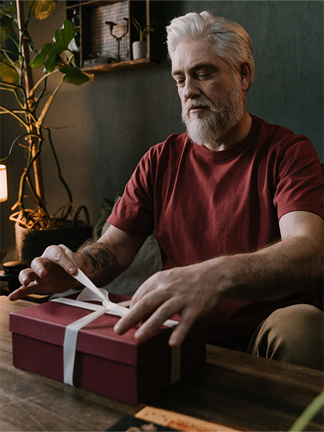 man met een baard die een cadeau inpakt